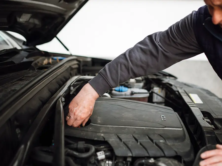 Mechanic leaning into an engine bay during a service
