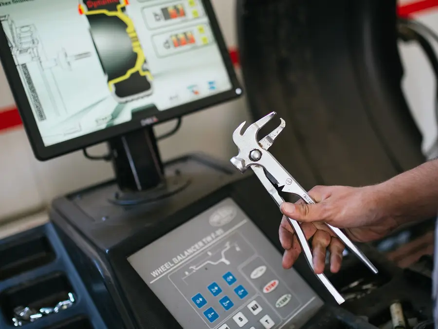 Wheel balancing machine with its screen showing a tyre